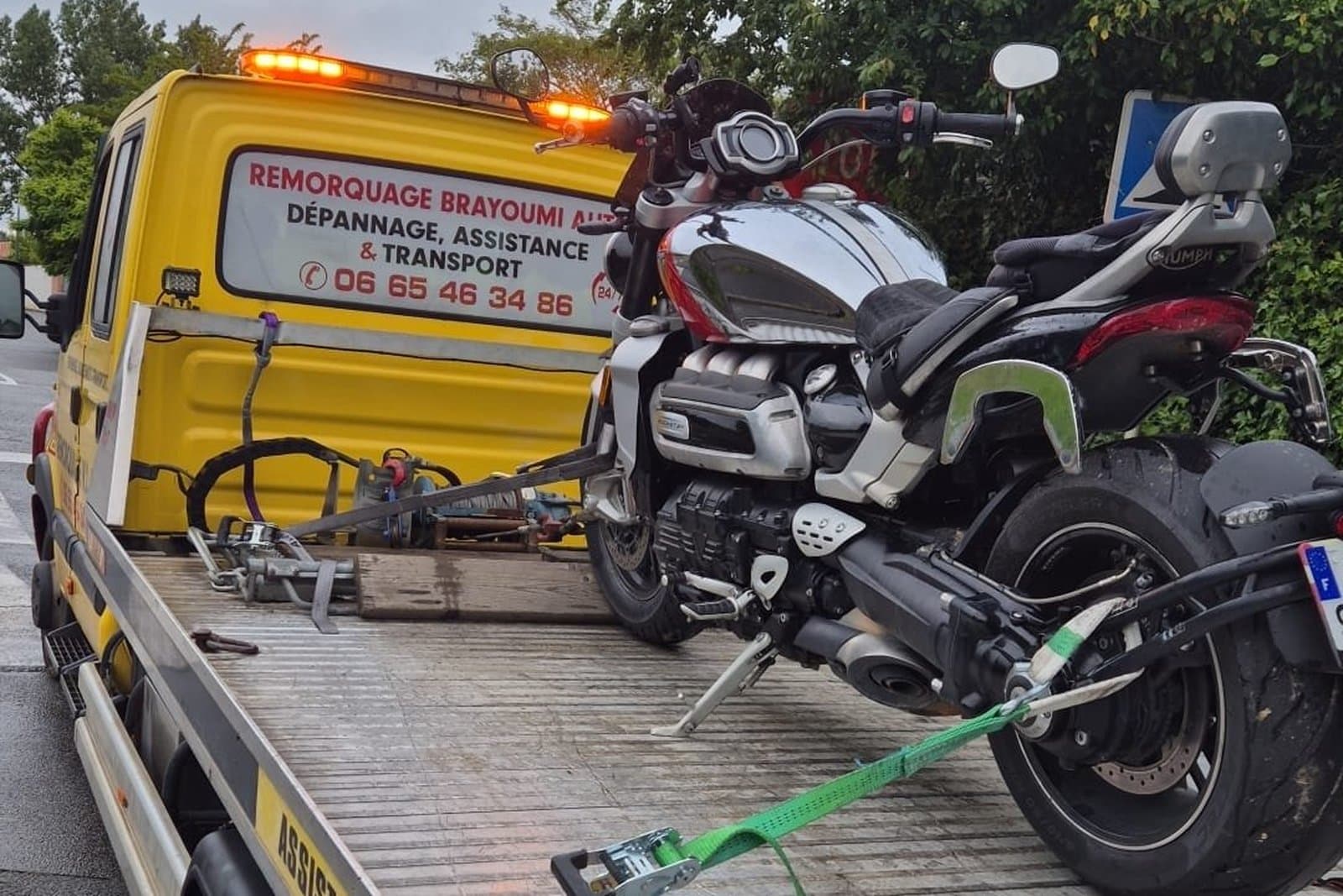 Moto sanglée sur le plateau d'un dépanneur partenaire