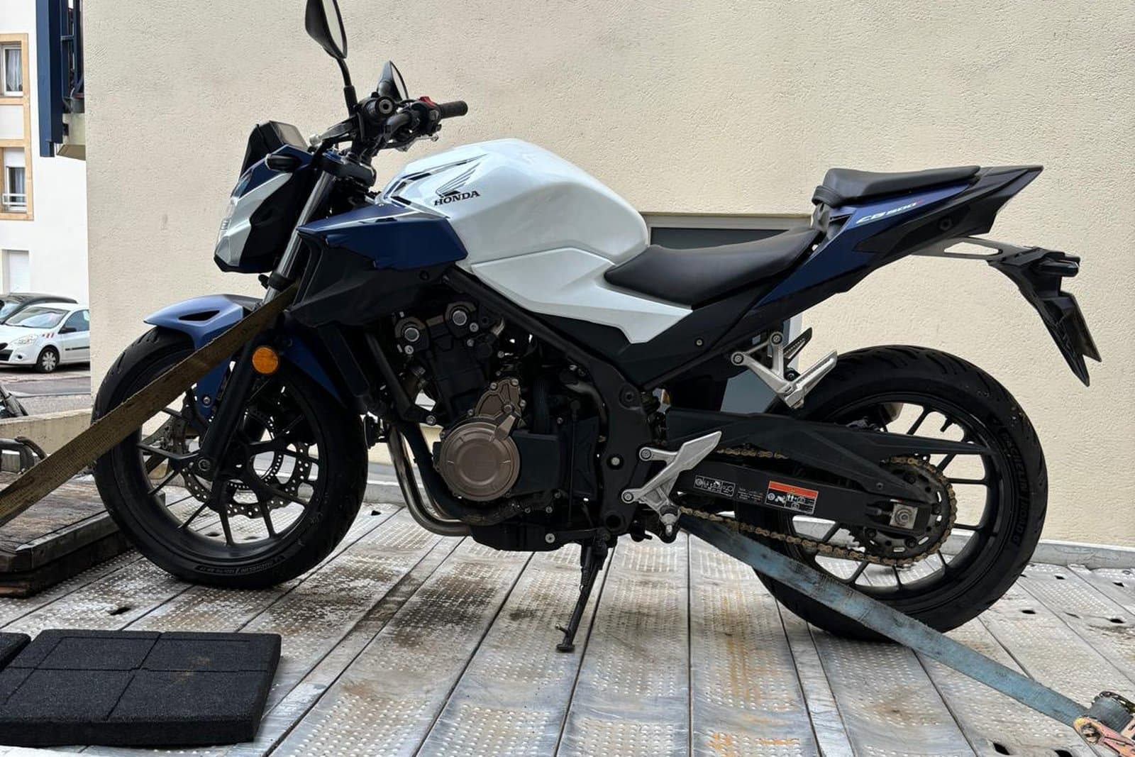 Roadster chargé sur le plateau d'un dépanneur partenaire, roue avant calée