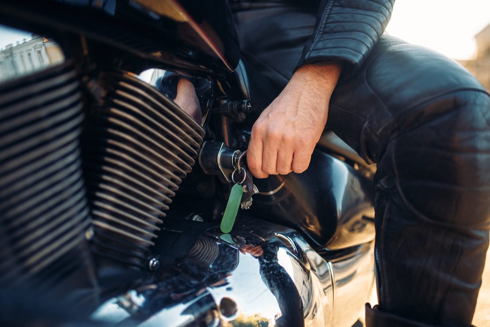 Motard tournant la clé de contact d'une moto qui ne démarre pas