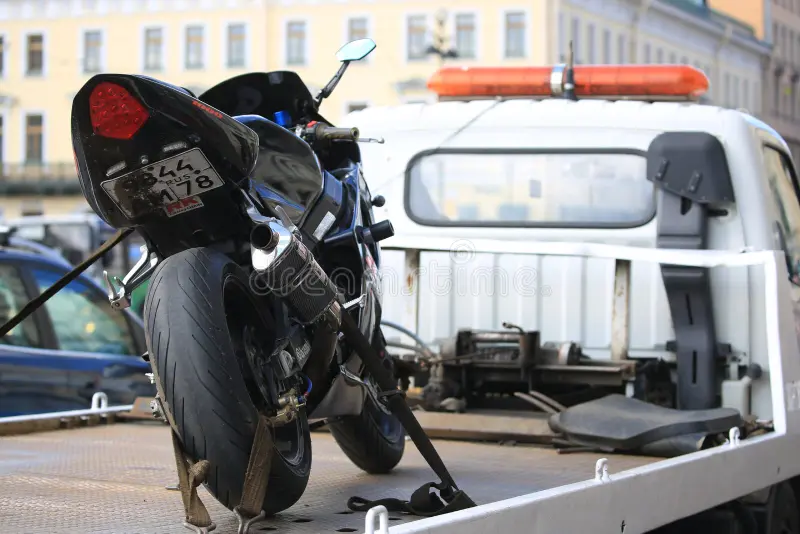 Moto sanglée sur un plateau de dépannage spécialisé avec sangles cadre