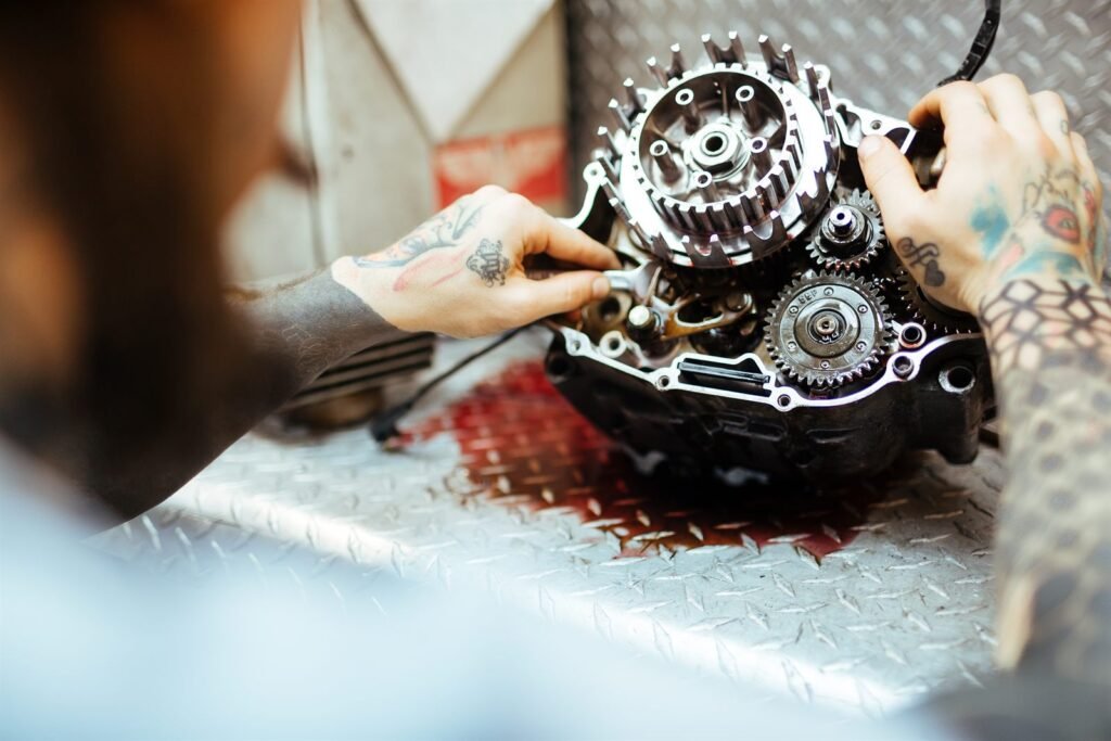 Technicien intervenant sur le démarreur d'une moto en atelier